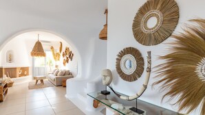 En moderne stue med et sofabord af glas, der viser en stor skulptur af et dyrehorn.