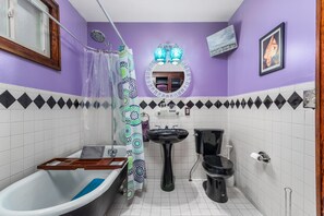 Une salle de bain équipée d’une baignoire, d’un lavabo, de toilettes et d’un rideau de douche.