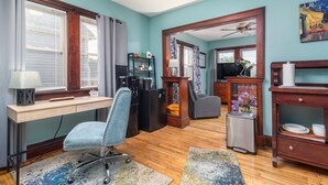 A room with a desk, chair, and a small trash bin. - Tremont  1BR  Pet Friendly, Private w/dedicated workspace and soaking tub! (Cleveland)