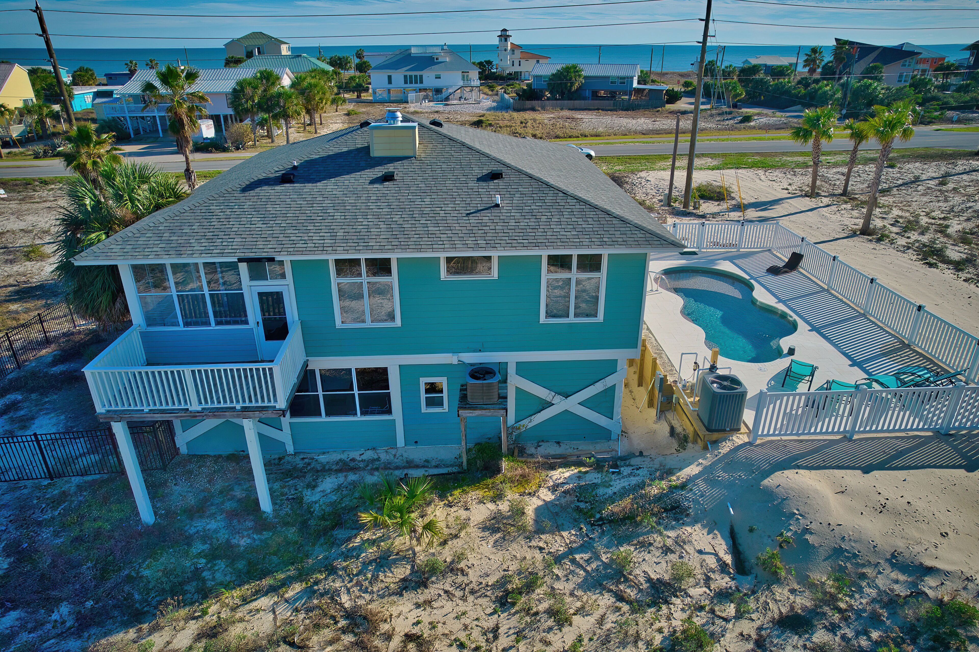 A two-story house with a balcony, a swimming pool, and a fenced patio area.