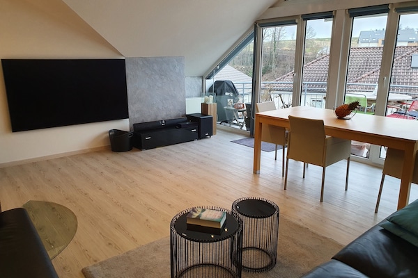 lichtdurchflutetes großzügiges Wohnzimmer mit großem Fernseher