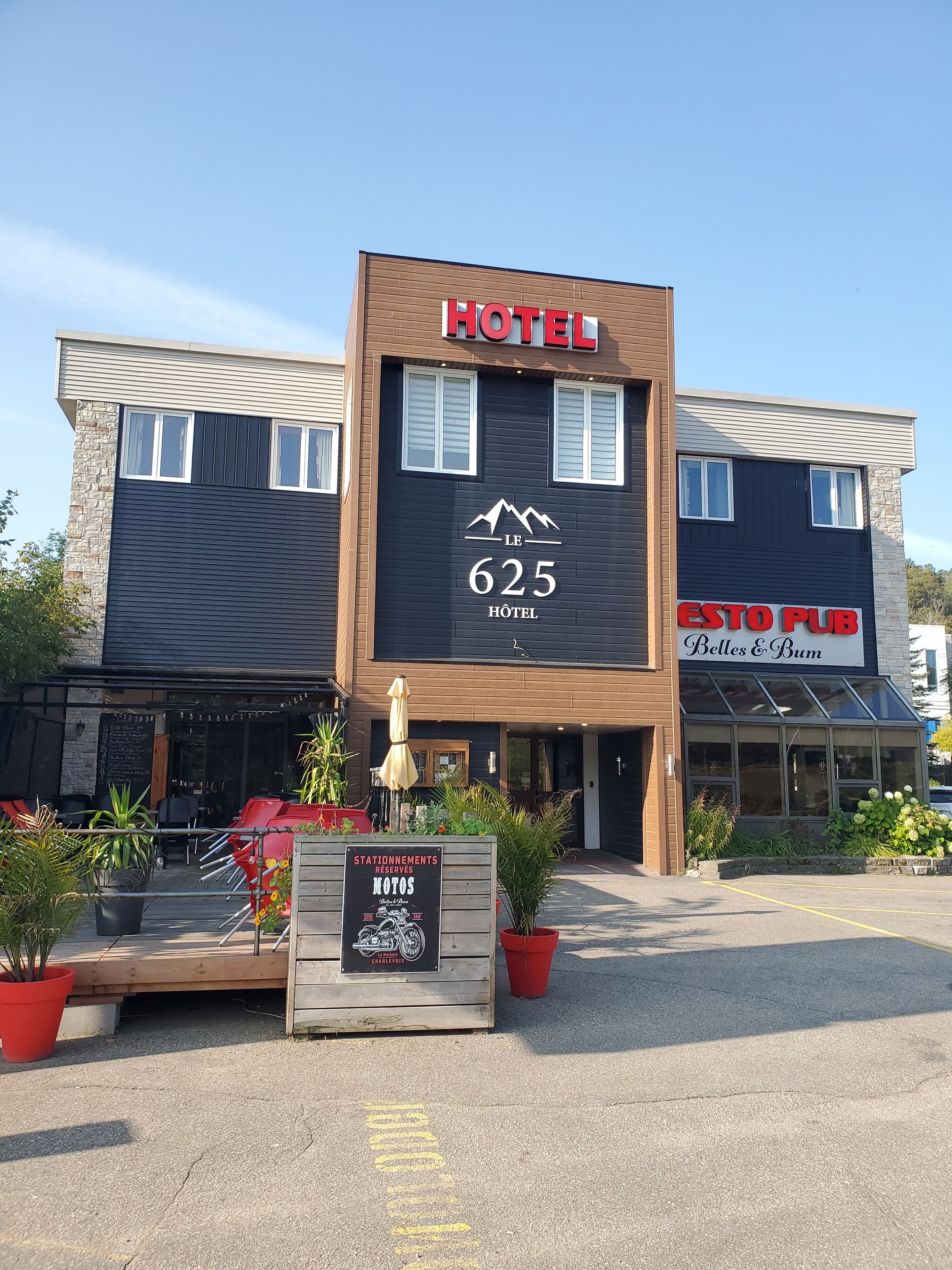 A hotel with a sign reading "HOTEL 625" and "ESTO PUB Belles & Bum" on the side.