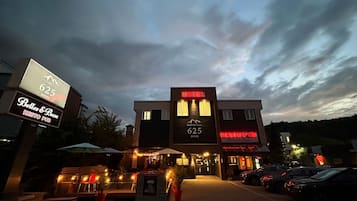 Un hôtel avec une enseigne indiquant qu’il s’agit du « Le 625 Hotel », et qui abrite un restaurant et un pub appelés « Belles & Bum » au rez-de-chaussée.