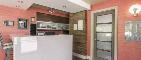 A reception area with a white counter, a television, and a wooden accent wall.