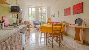 A cozy kitchen with a dining area, a television, and artwork on the walls. - Parenthèse - Villenauxe LA Grande (VILLENAUXE LA GRANDE)