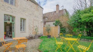 A stone house with a paved patio, outdoor seating, and a garden. - Parenthèse - Villenauxe LA Grande (VILLENAUXE LA GRANDE)