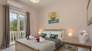Een hotelkamer met een bed, een bureau, een stoel, een lamp en een schilderij aan de muur.