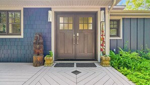 A house with a dark brown front door, a bear statue, and a decorative wall. - Beautiful Luxury Lake Front Cottage Georgian Bay (Georgian Bay)