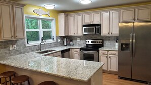 A kitchen with granite countertops, stainless steel appliances, and wooden cabinets. - Lake Hartwell on McKinney Point, near Clemson! (Westminster)