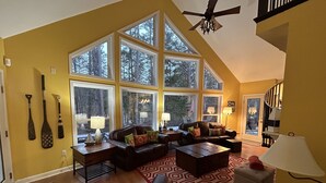 A spacious living room with large windows, a ceiling fan, and a staircase. - Lake Hartwell on McKinney Point, near Clemson! (Westminster)
