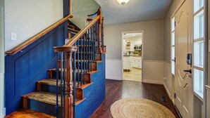 A staircase with wooden steps and balusters, leading to a landing with a light fixture above. - Entire Spacious, Cozy home with backyard retreat (Norman)