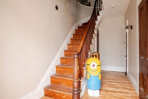 Una escalera de madera con barandilla que lleva a una puerta en la parte superior.