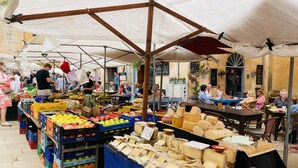 An outdoor market with various stalls selling fruits and cheeses. - - BE OUR GUEST! - Sea, pleasure, private roof terrace (Ses Salines)