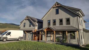 Une maison à deux étages avec un garage, une véranda et une allée.