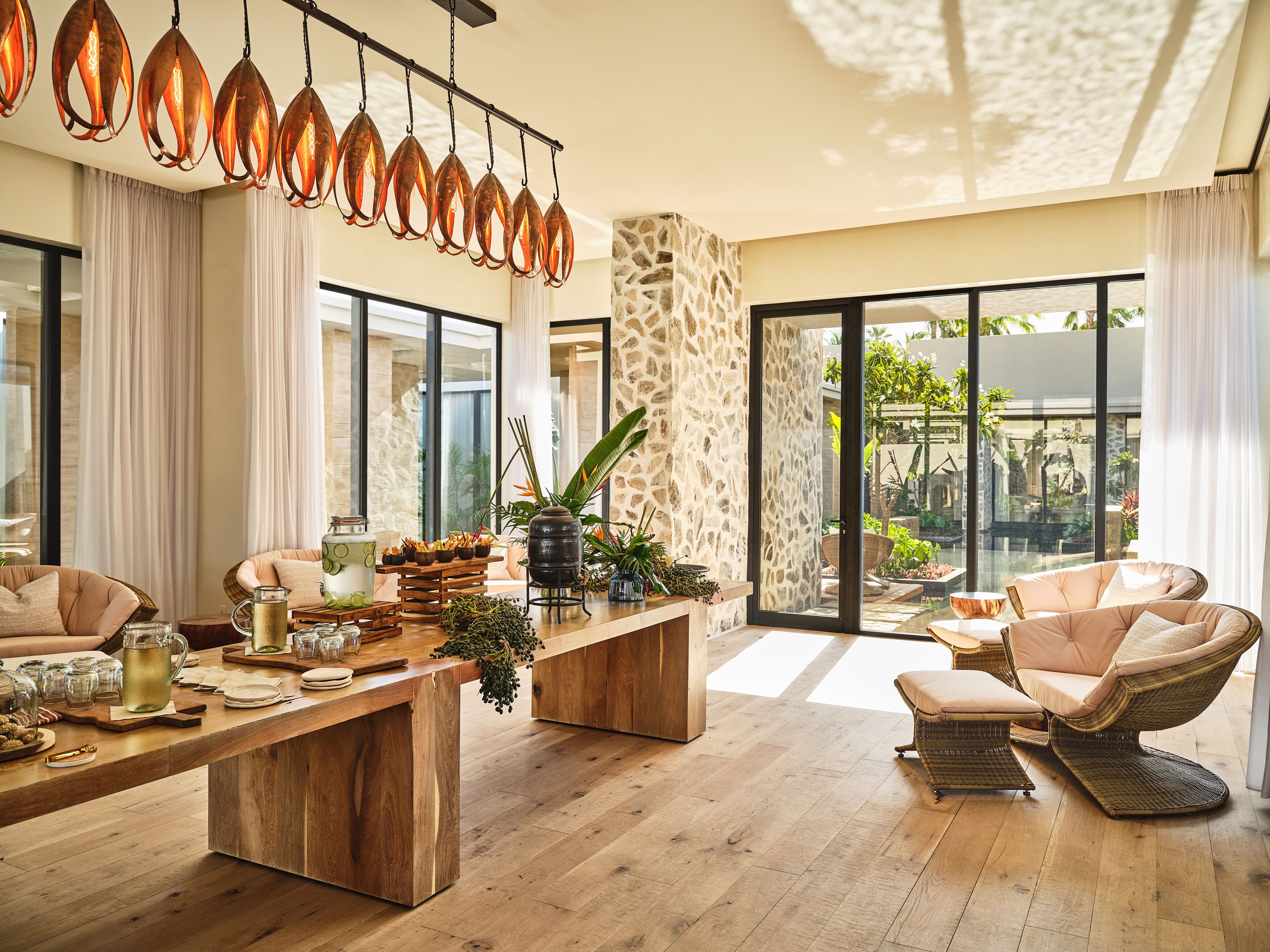 Amplia sala de estar con mesa de centro de madera, asientos cómodos y un ventanal con vistas al exterior.