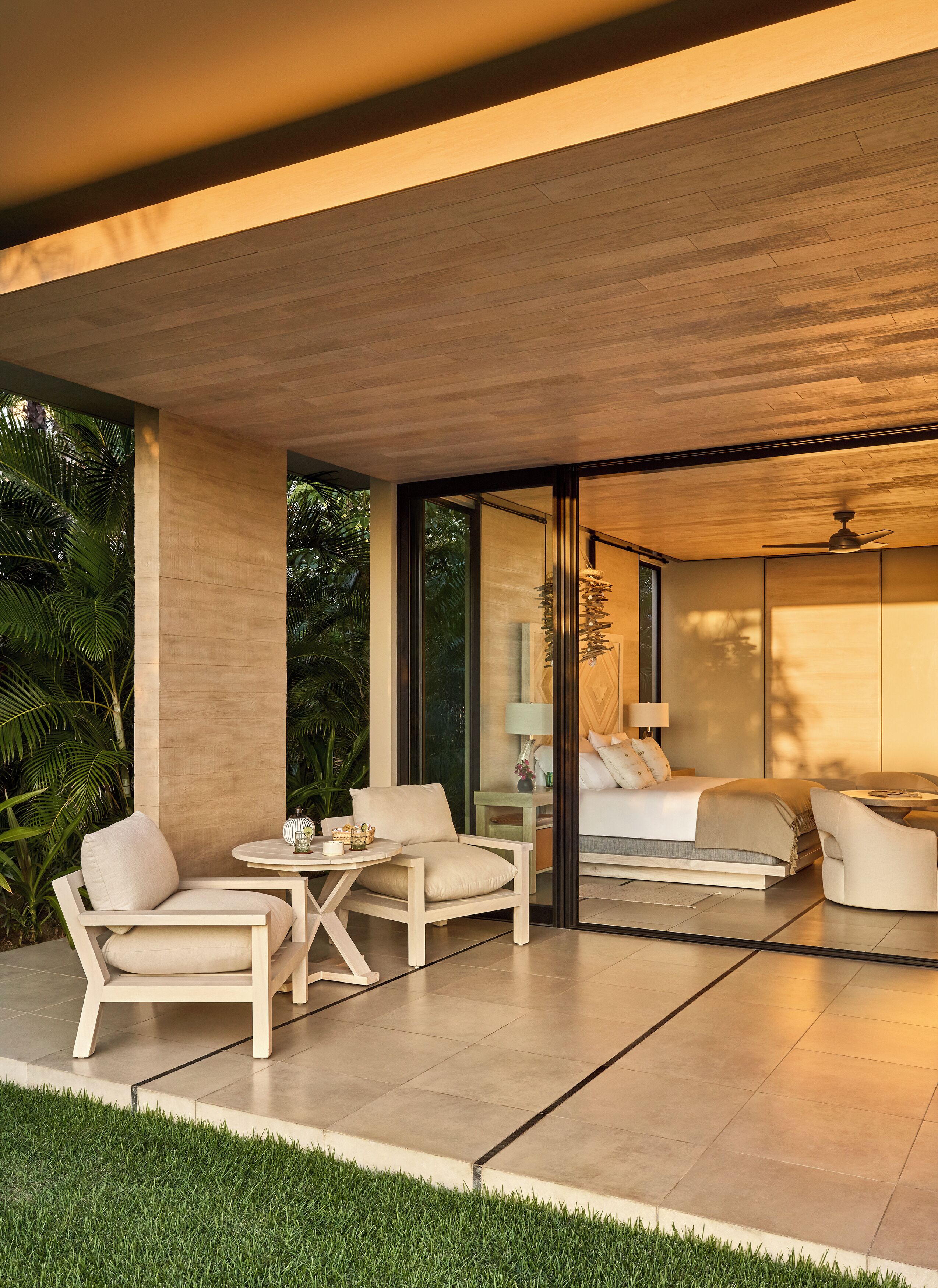 A modern outdoor living area with a sofa, chairs, and a table.