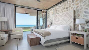 Un dormitorio moderno con una cama grande, una zona de estar y vista al océano.