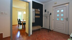 A hallway with a dining area, a coat rack, and a door with frosted glass panels. - Holiday home mit Terrasse und Grill (Pula)