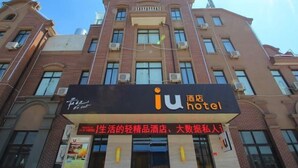 Un hôtel avec une enseigne indiquant « iu hotel » et, en dessous, une autre faisant la publicité de « produits légers pour la vie, hôtel, données personnelles ».