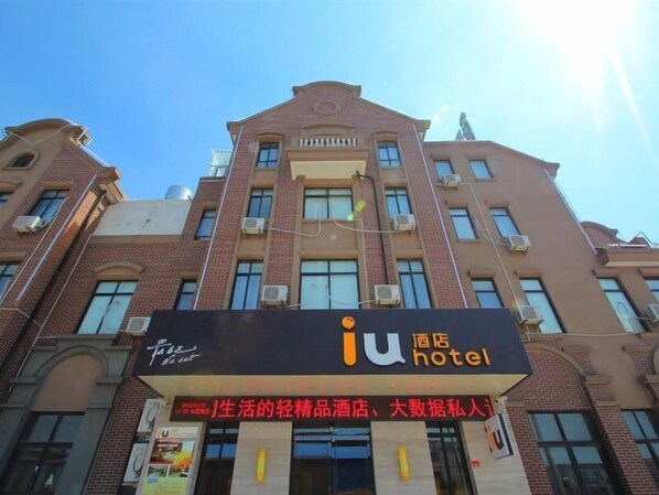 A hotel with a sign reading "iu hotel" and a sign below it advertising "life's light products hotel, data private person". - IU Hotel (Shanghai)