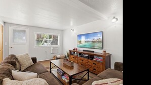 A living room with a sofa, coffee table, TV, and storage unit.