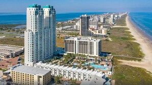 A high-rise hotel with multiple floors, a beach view, and a pool area. - 3/3 Sapphire Condo 23rd Floor, Ocean & Bay View Balconies, Corner Unit, NO FEES! (South Padre Island)