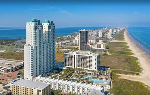 Un hôtel de grande hauteur, avec de nombreux étages, une vue sur la plage et un espace piscine.