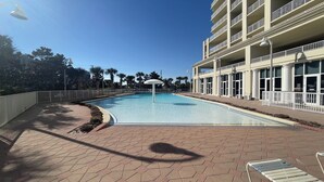A swimming pool with a white umbrella, surrounded by a brick walkway and a white fence. - Walking distance to the beautiful Gulf of Mexico beaches (Miramar Beach)