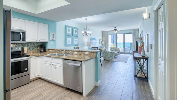 A modern kitchen with white cabinets, a granite countertop, and a dishwasher. - Walking distance to the beautiful Gulf of Mexico beaches (Miramar Beach)