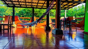 A covered outdoor seating area with a hammock, chairs, and a tiled floor. - Secluded Home with a private beach! On an island accessible by boat. (San Dionisio)