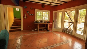 A room with a tiled floor, a ceiling fan, a window, and a door leading outside. - Secluded Home with a private beach! On an island accessible by boat. (San Dionisio)