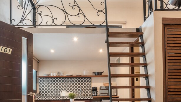 Ein modernes Interieur mit Essbereich, einem Bett und einer Treppe.