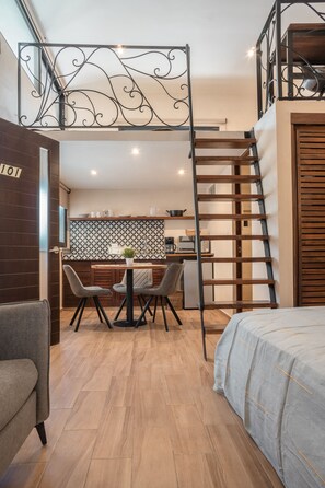 A modern interior with a dining area, a bed, and a staircase. - Casa Luz Downtown Apartments Tulum (Tulum)