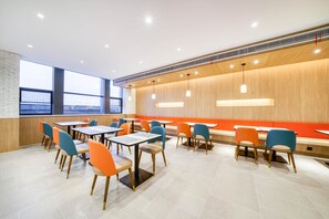 A modern dining area with tables and chairs, large windows, and a wooden accent wall. - Hanting Hotel (china Home Textile City Store in Xu (Jiaxing)
