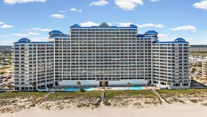 Un grand hôtel à plusieurs étages, doté d’un atrium central, de nombreux balcons et d’un espace piscine.