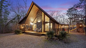 A log cabin with a stone fireplace, a deck, and a playground. - ❤️Heart of Hochatown | Modern Fam Friendly Cabin, Fun Games, Hottub, Firepit ✨ (Broken Bow)