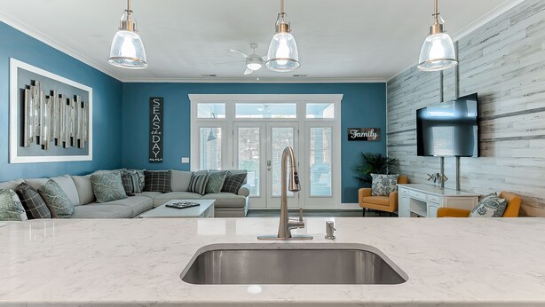 Een moderne keuken met een centraal eiland, een inbouwspoelbak en hanglampen.
