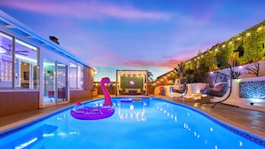 Una piscina con sillones de descanso, un ventilador de techo y vistas al cielo.