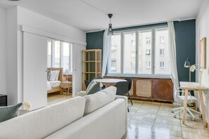 Relax in this inviting living space with a sofa, table, and chair, offering a view of the city.