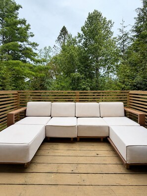 A wooden deck with a sectional sofa and a wooden railing. - Jiminy Peak Resort Townhome, Sleeps 10, Pool, Hot Tubs, Sauna & Deck (Hancock)