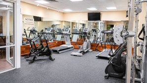 A gym with various exercise equipment including treadmills, stationary bikes, and weight machines.