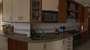 Una cucina con piani di lavoro in granito, elettrodomestici in acciaio inossidabile e mobili in legno.