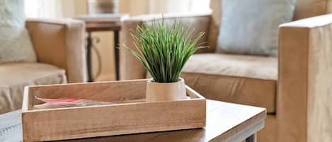 Ein Holztablett mit einem Topfpflanzen auf einem Holztisch in einem Wohnzimmer.