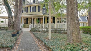 A two-story house with a porch, a pathway leading to the entrance, and trees surrounding the property. - Riverside Cottage: Close to Ocean and Myrtle Beach (Murrells Inlet)