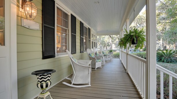 A covered porch with white railings, wicker rocking chairs, and a potted plant. - Riverside Cottage: Close to Ocean and Myrtle Beach (Murrells Inlet)
