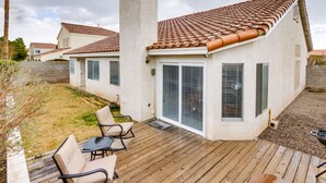 Una casa con tetto in tegole, un camino e una terrazza con mobili da esterno.