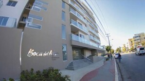 Un immeuble à plusieurs étages, sur lequel on peut lire l’inscription « Boca del Mar ». Il présente un design moderne, avec des balcons et une entrée bien visible, accessible par quelques marches.