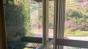 Een houten terras met een glazen deur naar een patio.