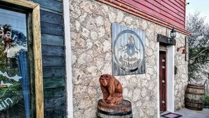 Un edificio rustico con facciata in pietra, una scultura di botte di legno e un cartello con su scritto “Cabanas Big Mountain”.