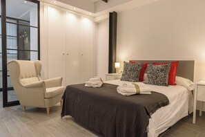 Een hotelkamer met een bed, een stoel, een kledingkast en een nachtkastje.